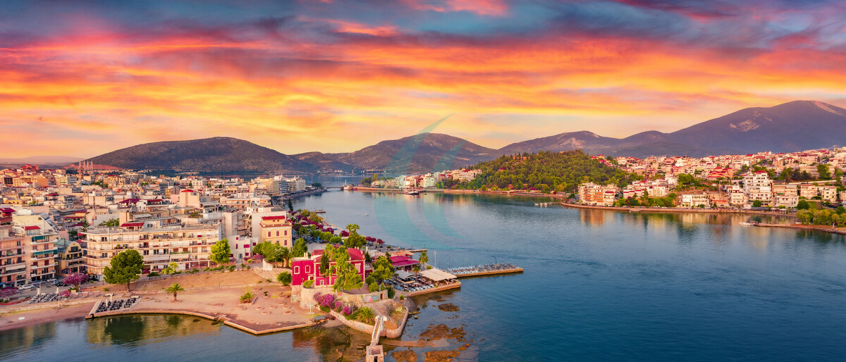 Bunte sommerliche Stadtansicht der Stadt Chalkida. Dramatischer Sonnenaufgang über der Ägäis, im Nördlichen Euböischen Golf. Herrliche Morgenszene auf der Insel Euböa, Griechenland, Europa. Hintergrund zum Thema Reisen.