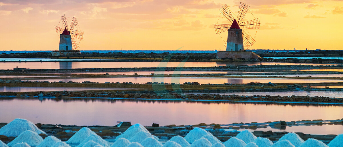 Sonnenuntergang bei den Windmühlen im Salzverdunstungsbecken von Marsala auf Sizilien, Italien