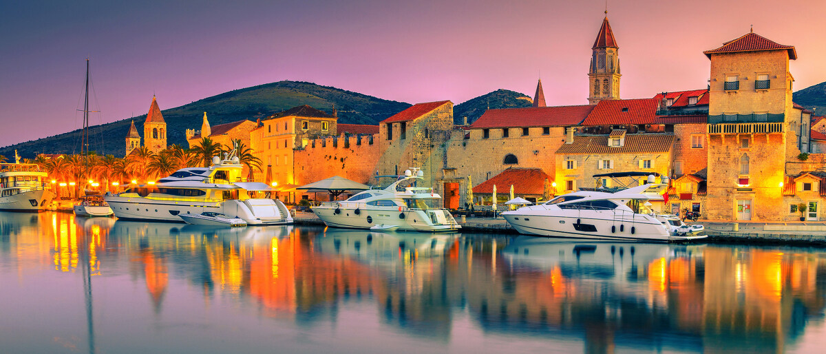 Fantastisches Reiseziel für Urlaub und Ferien. Wunderschöner farbenfroher Sonnenaufgang mit Hafen und Luxusyachten. Mittelalterliche und historische Altstadt, Trogir, Kroatien, Europa