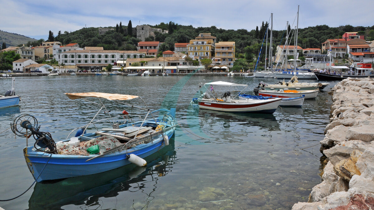 Fischerboote und Segelyachten im Hafen von Kassiopi unter der Burg