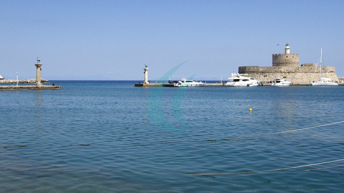 Hafeneinfahrt von Mandraki mit Hirschen auf Säulen, Yachten und dem Fort Agios Nikolaos