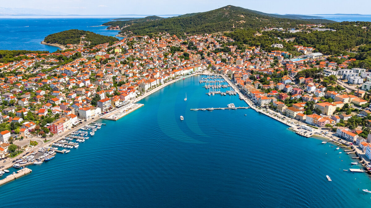 Luftaufnahme der Stadt Mali Lošinj und ihres Hafens, umgeben von mediterranem Wald, Kroatien