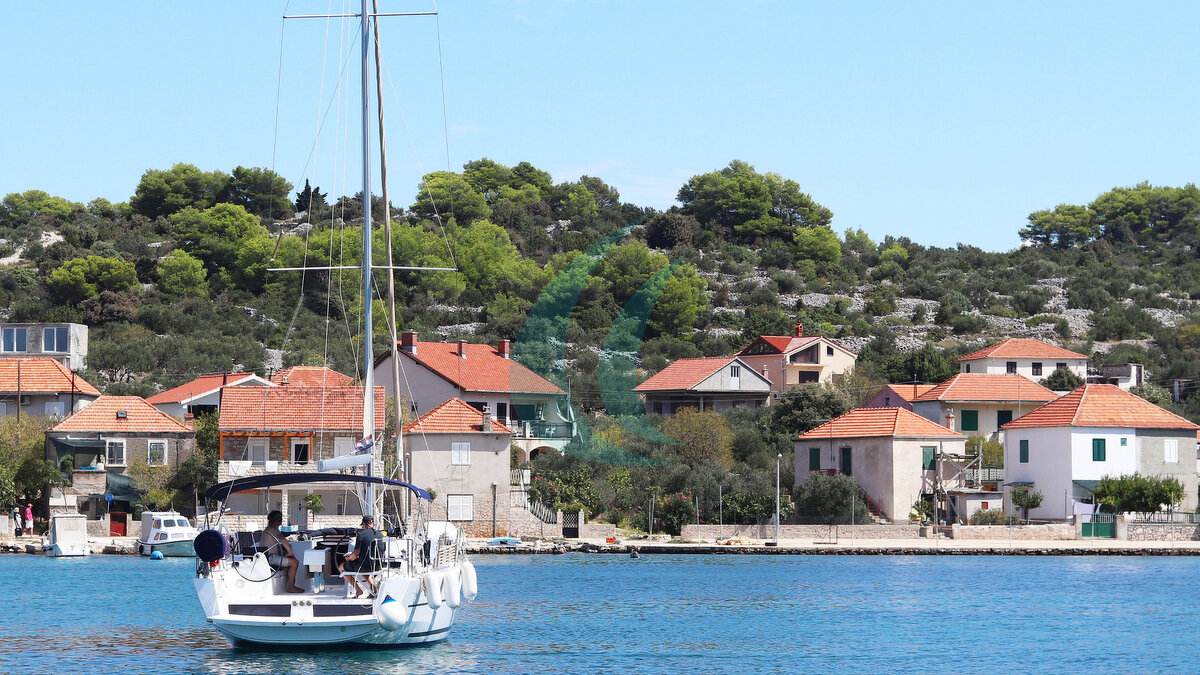 Panorama eines Jachthafens im Ort Jezera in Kroatien, in der Region Dalmatien. Die im Hafen eines ruhigen Fischerdorfs vertäuten Schiffe an einem sonnigen, klaren Tag. Tourismus und maritimes Gewerbe. Insel Murter.
