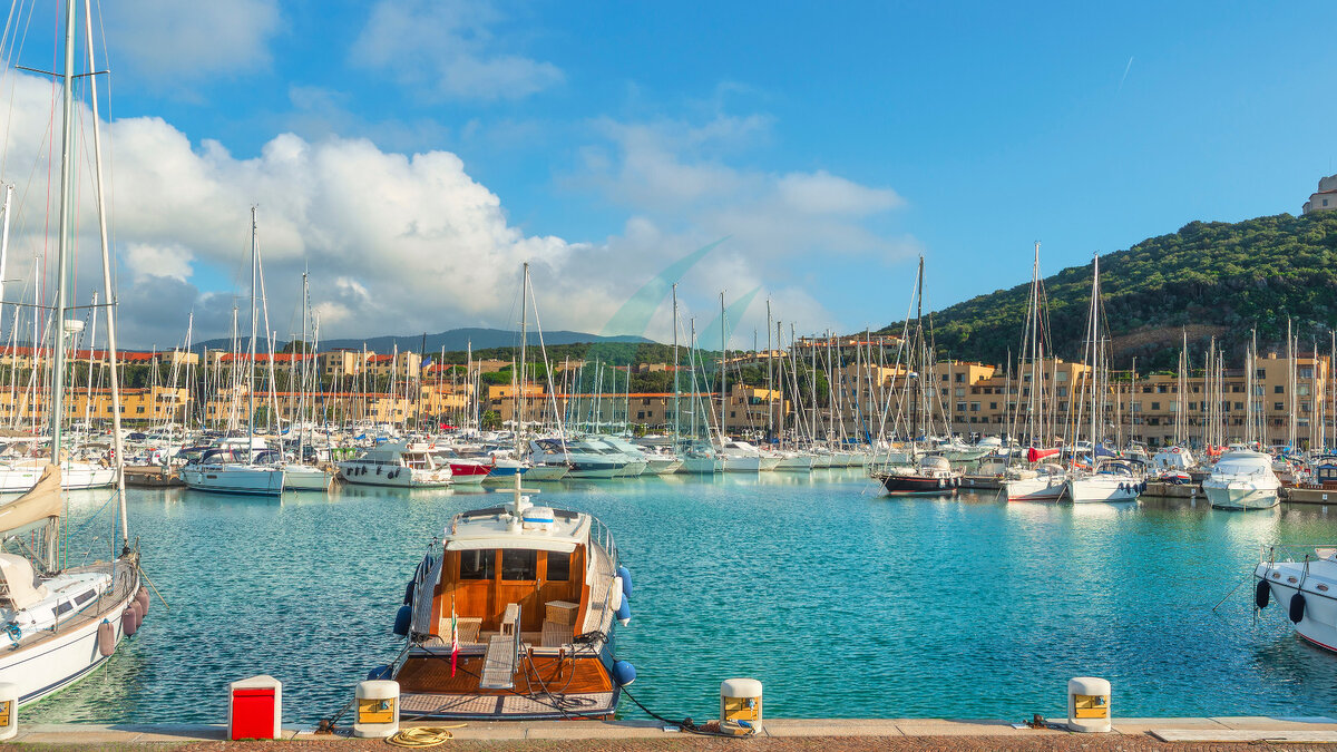 Blick auf Luxusyachten, Motorboote und Segelboote, die im Jachthafen von Punta Ala mit dem Turm auf dem Hügel vor Anker liegen. Grosseto, Toskana, Italien