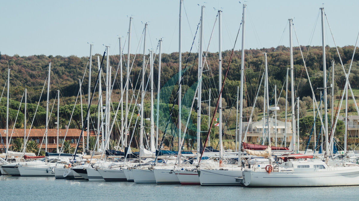 Yachtliegeplätze im Hafen, Yachtclub im Hafen von Marina di Scarlino, Italien. Wunderschöne Yachten vor der Kulisse der italienischen Küste